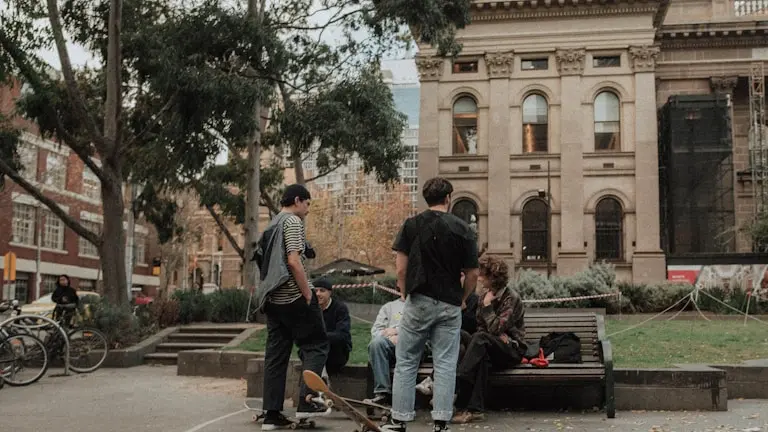 people on bench near brown building